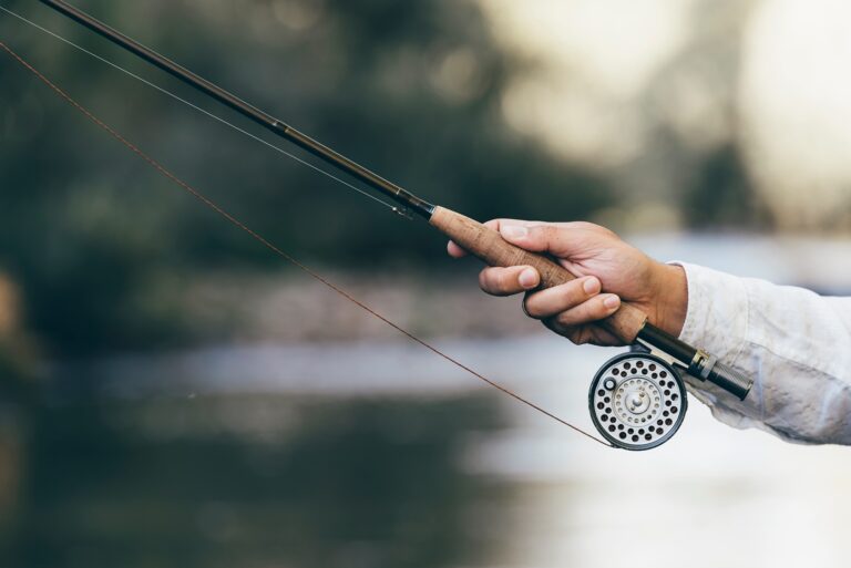 Fly fishing rod in fisherman hand.